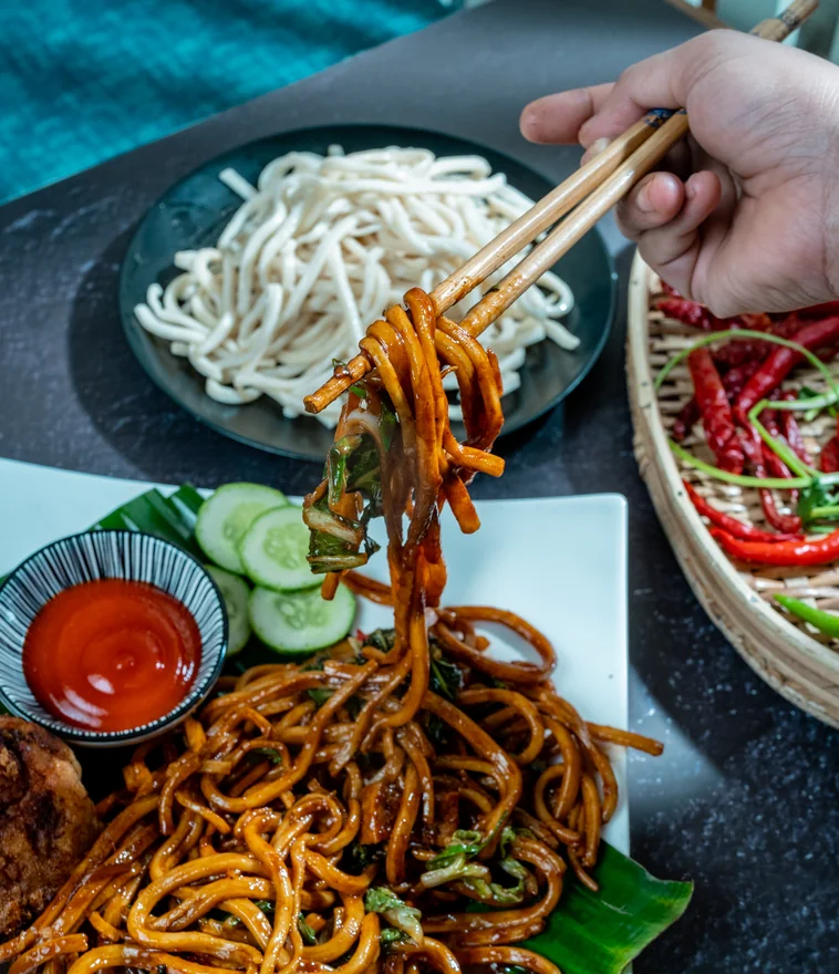 Mee goreng noodles lifted with chopsticks