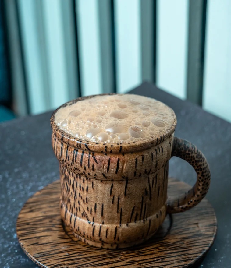 Hot teh tarik in traditional wooden mug